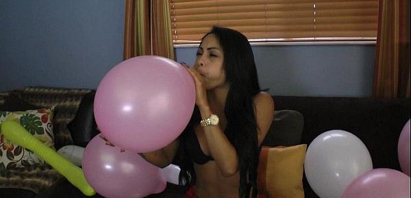  Latina blowing to pop balloons